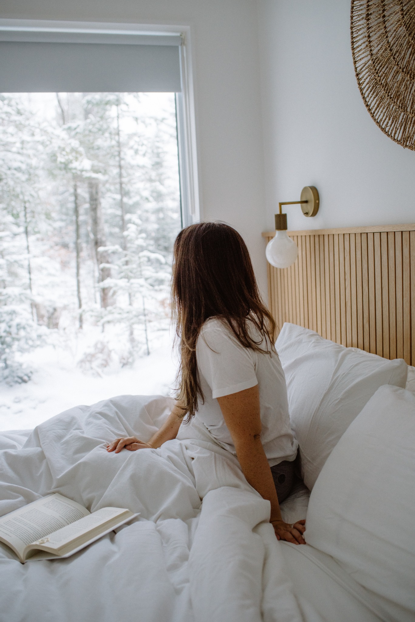 Cozy bedroom scene at WOLM Cabin with a snowy forest view