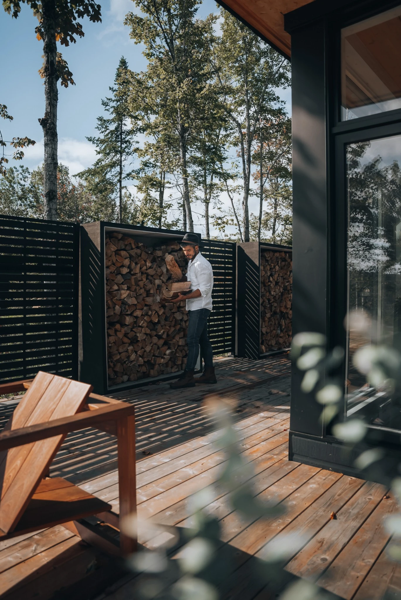 Outdoor deck and firewood area at WOLM Cabin surrounded by the forest